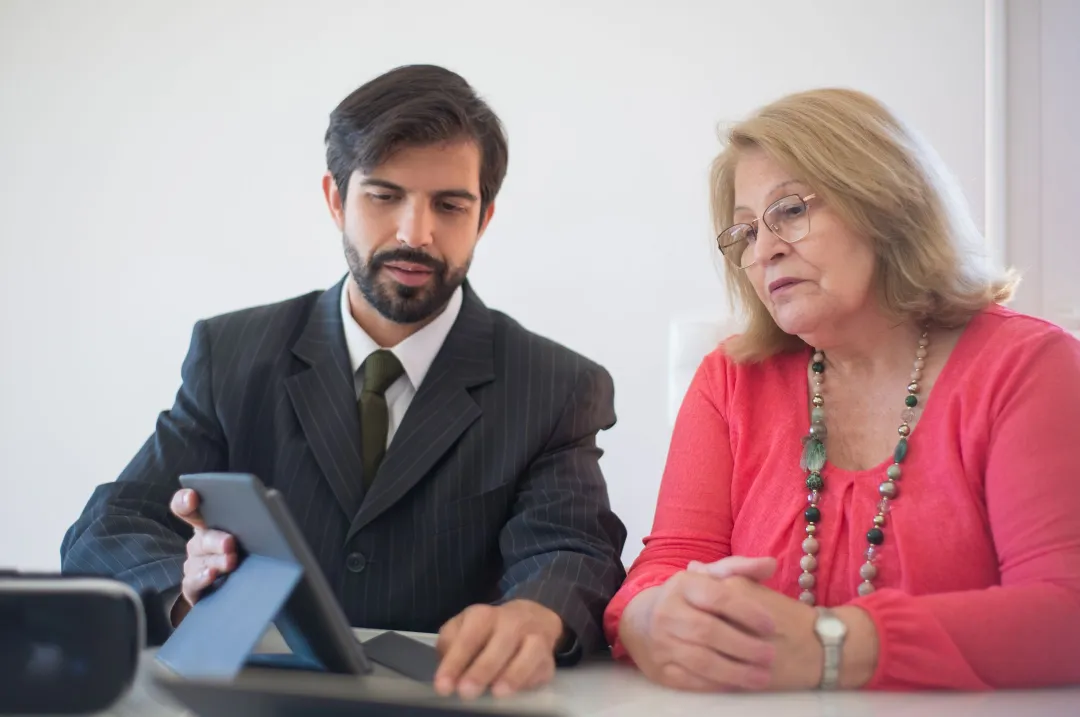 Financial advisor explaining long-term investment growth to a client on a tablet