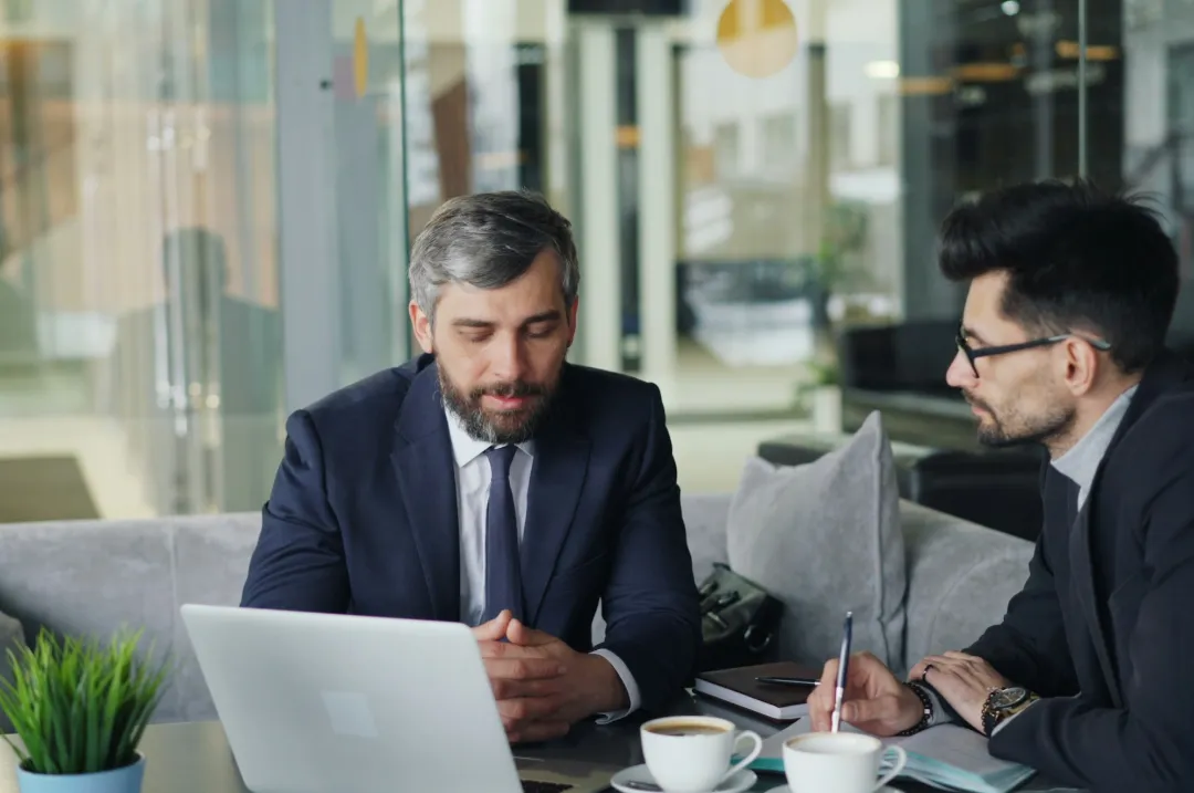 Business owner discussing a financial plan with an advisor over a laptop