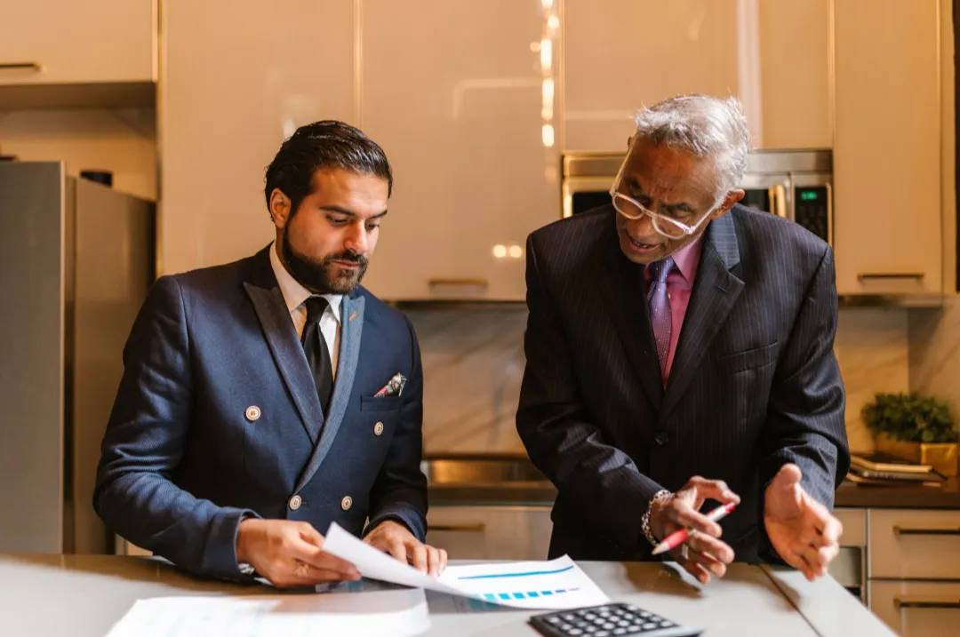Senior business owner reviewing documents with a younger partner